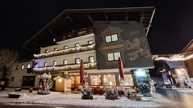 A hotel with a balcony, a Christmas tree, and outdoor seating. - Ferienwohnung mit Küche und Balkon (Reit im Winkl)