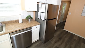 A kitchen with stainless steel appliances, white cabinets, and a granite countertop. - Claremore Whole House - Just Fully Remodeled - Dogs Allowed - No Checkout Chores (Claremore)