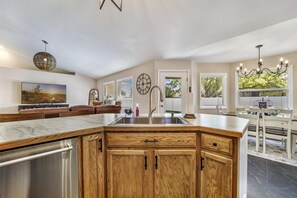 Enjoy meals in the kitchen with a central island and dining area, featuring a table and chairs.