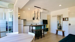 Una cucina moderna con angolo pranzo, televisione e divano.