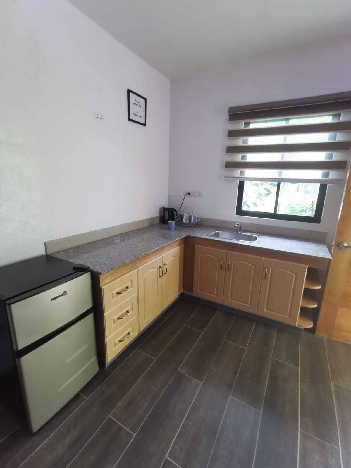 A compact kitchen with a built-in stove, a sink, and wooden cabinets.