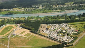 Luchtbeeld van een golfbaan met een ruime parkeerplaats en een rivier op de achtergrond.