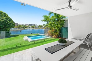 Une terrasse extérieure moderne, dotée d’une piscine, d’un ventilateur de plafond et offrant une vue sur l’océan.
