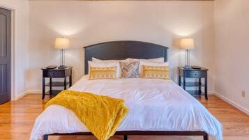 A bedroom with a large bed, two bedside tables, and a wooden ceiling.