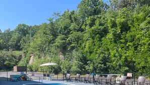 Une piscine avec des chaises longues et un panneau indiquant qu’il est interdit de plonger.