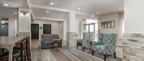 A spacious living area with a dining table, sofas, and a patterned rug.