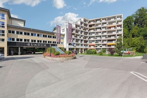 Ein modernes Gebäude mit mehreren Balkonen und einem zentralen Innenhof mit Blumen.