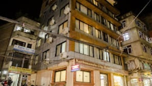 A multi-story building with visible signage for a hotel and other businesses. - MeroStay 206 Hotel KU (Kathmandu)