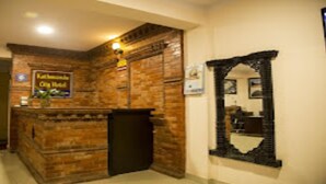 A reception area with a wooden reception desk, a mirror, and a sign above the desk. - MeroStay 206 Hotel KU (Kathmandu)
