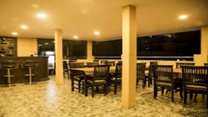 A spacious indoor area with a bar, multiple seating arrangements, and a patterned floor. - MeroStay 206 Hotel KU (Kathmandu)