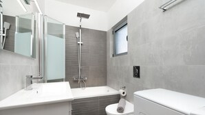 A modern bathroom with a glass shower enclosure, a white sink, and a toilet. - MTC-AN Apartment by the sea and Airport (Markopoulo Mesogaias)