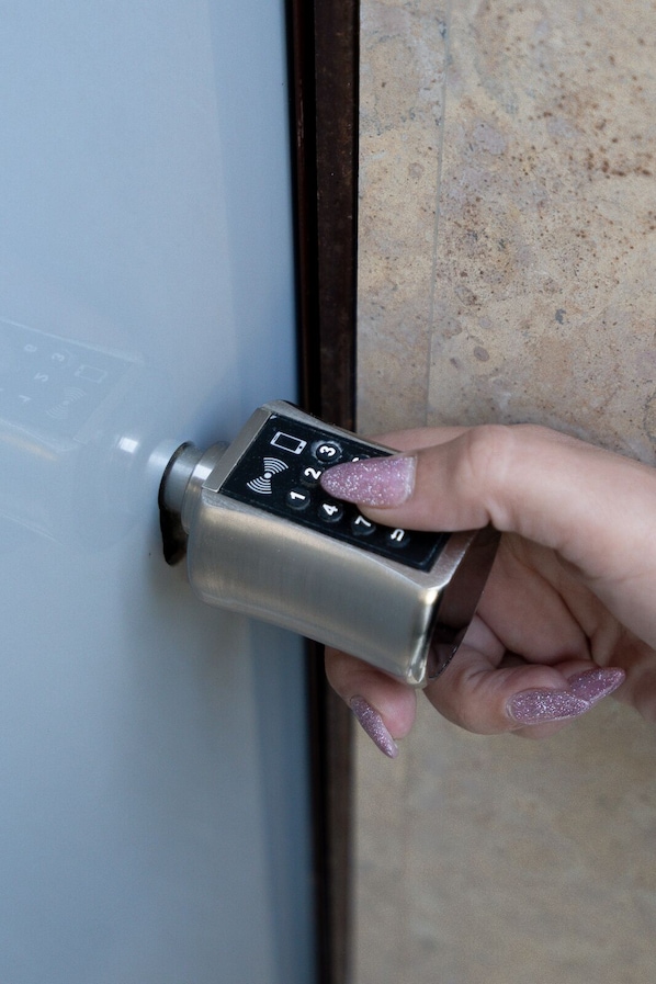 A hand using a keypad lock on a door. - MTC-AN Apartment by the sea and Airport (Markopoulo Mesogaias)