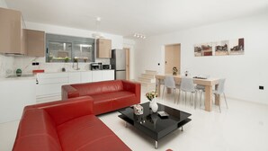 A modern apartment with a living room, kitchen, and dining area. - MTC-AN Apartment by the sea and Airport (Markopoulo Mesogaias)