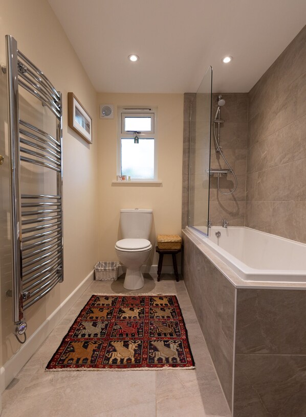 Une salle de bain moderne équipée de toilettes, d’une douche et d’une baignoire.