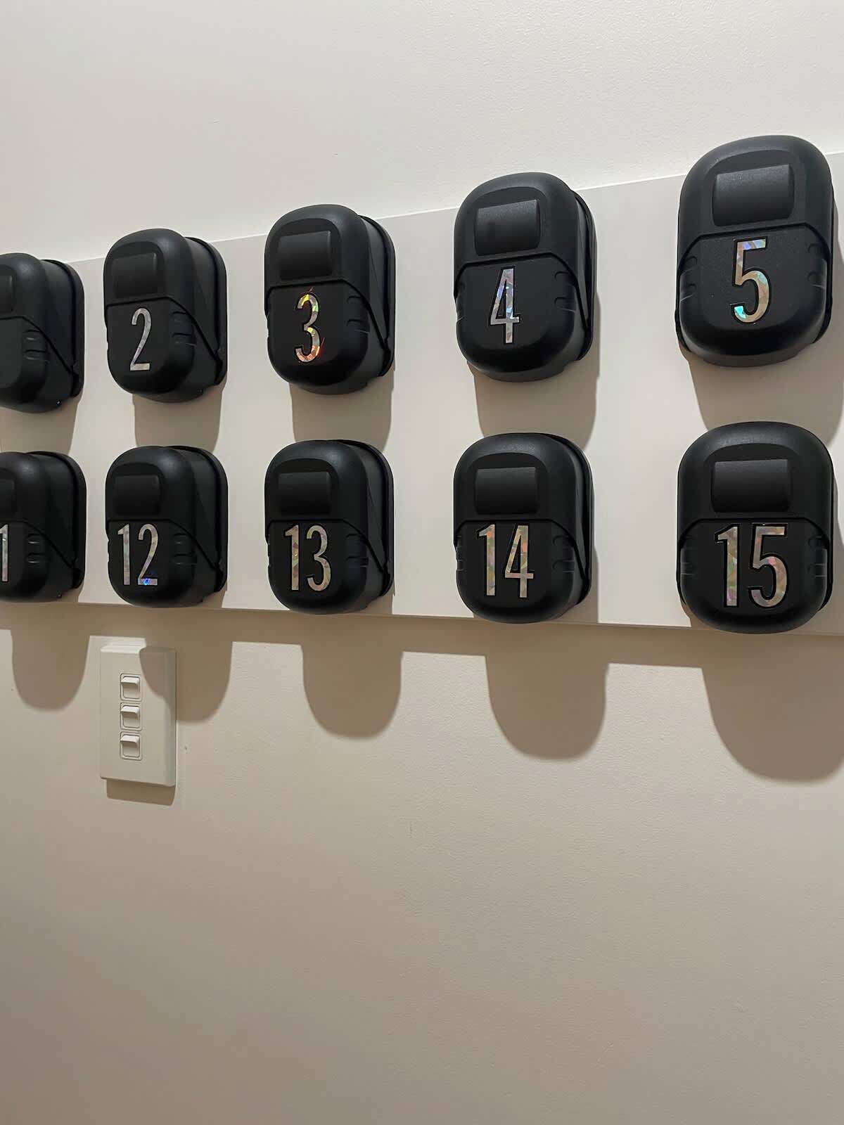A wall-mounted control panel with numbered buttons from 1 to 15.