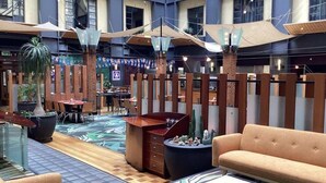 A spacious indoor area with high ceilings, modern furniture, and a central seating area.