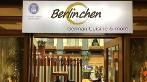 The exterior of a restaurant named 'Berlinchen' offering German cuisine and more.
