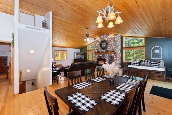 A dining area with a wooden table, chairs, and a fireplace.