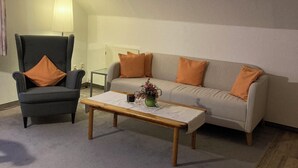 Una sala de estar con sofá, sillón y mesa de centro.