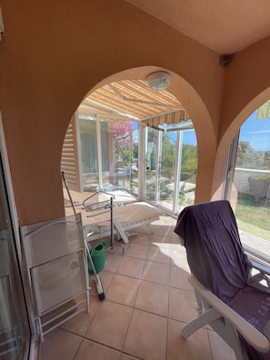 Relax in this serene room with a garden view, featuring a large arched window and a comfortable bed with a headboard.