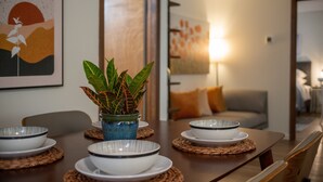 A dining table set with bowls and a potted plant.