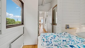 A room with a bed, a window, and a door leading to another room. - Beach front home in Rønne with WiFi (Rønne)