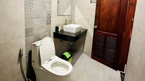 A compact bathroom with a toilet, sink, and mirror. - Laluna Guesthouse (Siem Reap)