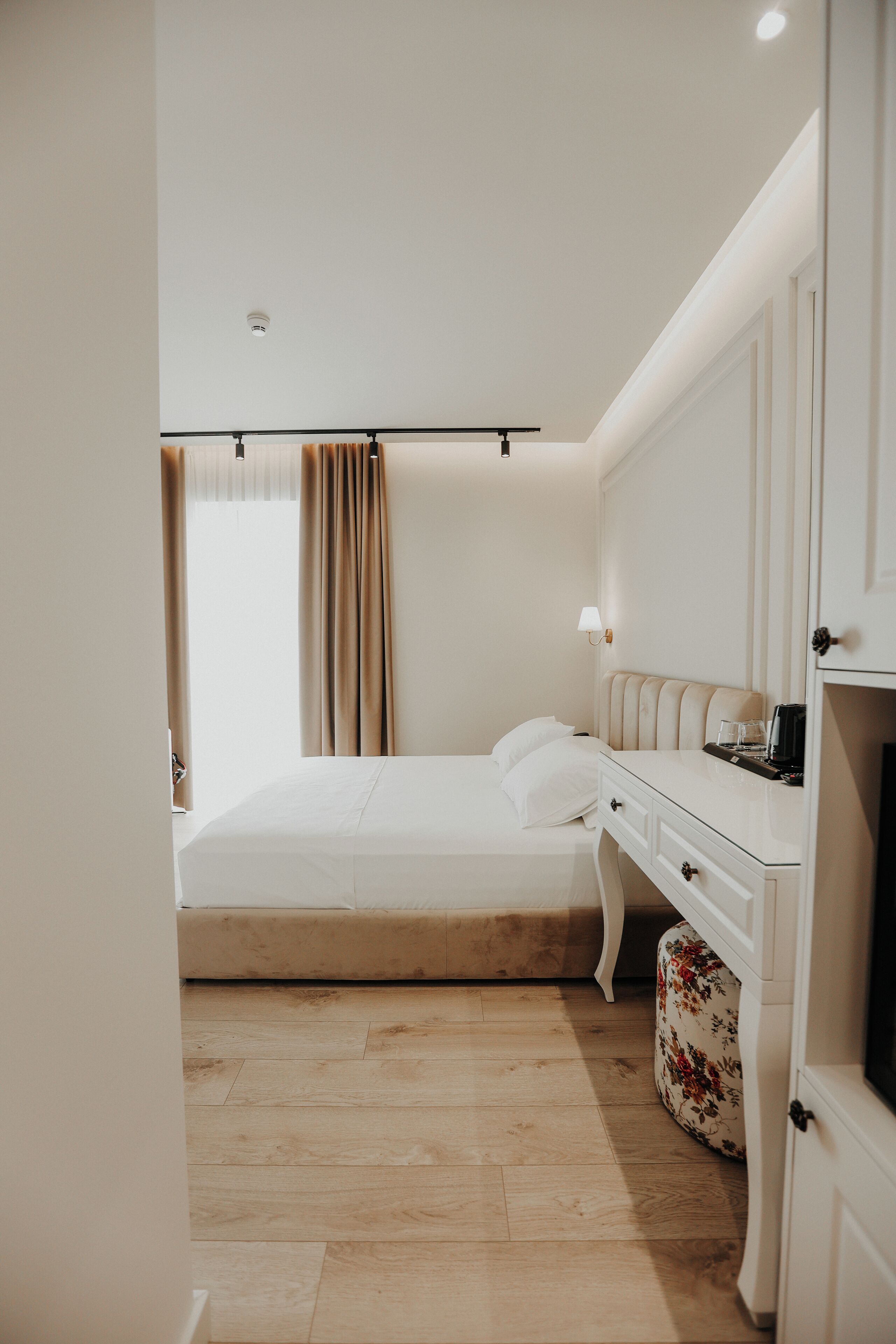 Une chambre d’hôtel avec un lit, une table de chevet, une lampe et un petit meuble.