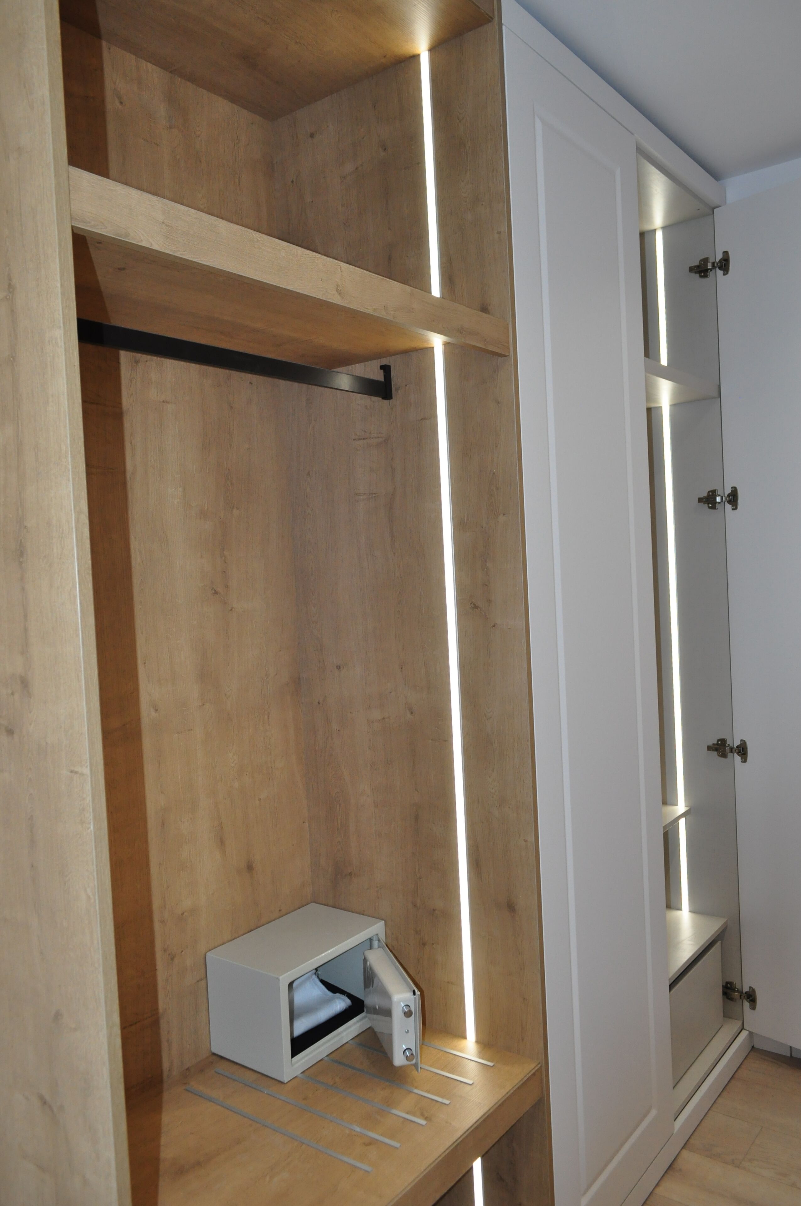 Ein Zimmer mit Holzböden, einem weißen Schrank und einer fest eingebauten Heizung.