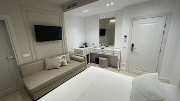 Un dormitorio moderno con cama, sofá, escritorio y televisor.