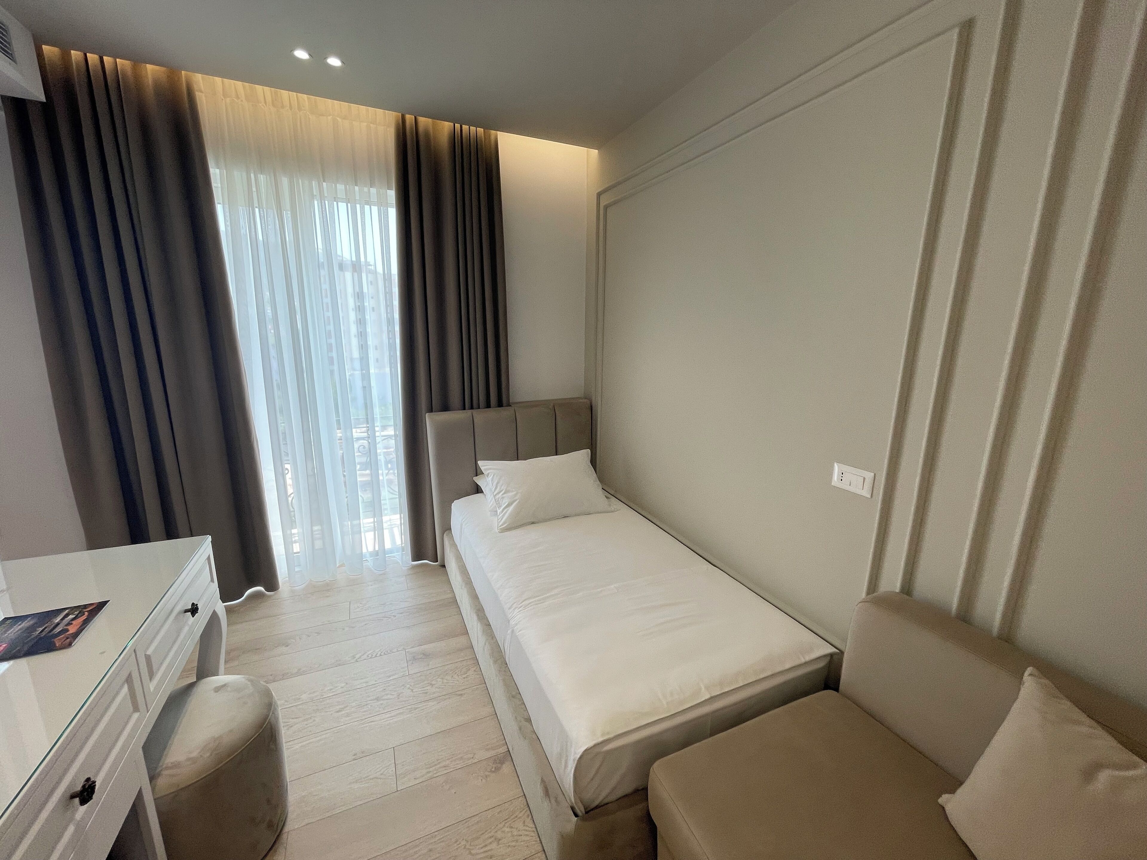 A hotel room with a bed, a desk, and a chair.