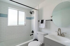 A bathroom with a bathtub, toilet, and sink. - Fillmore Unit 3 | 2BR/1BA (Cape Canaveral)