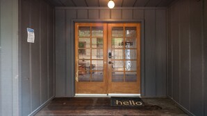 A wooden door with glass panels and a doormat reading "hello". - Sierra Mountain Escape - Brand new spa/game room! (Oakhurst)
