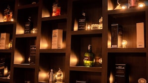 Una estantería exhibe diversas botellas y cajas de licores.