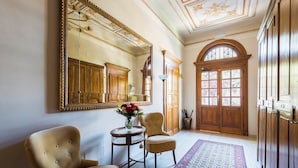 A spacious hallway with a large mirror, wooden doors, and a patterned rug. - Villa Savioli (Bologna)
