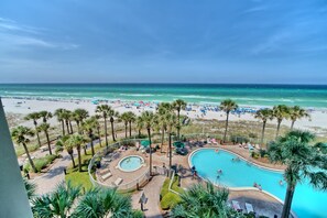 A resort with a pool, beach, and palm trees. - Grand Panama Resort! Sleeps 8 ~ Gulf Front (Panama City Beach)