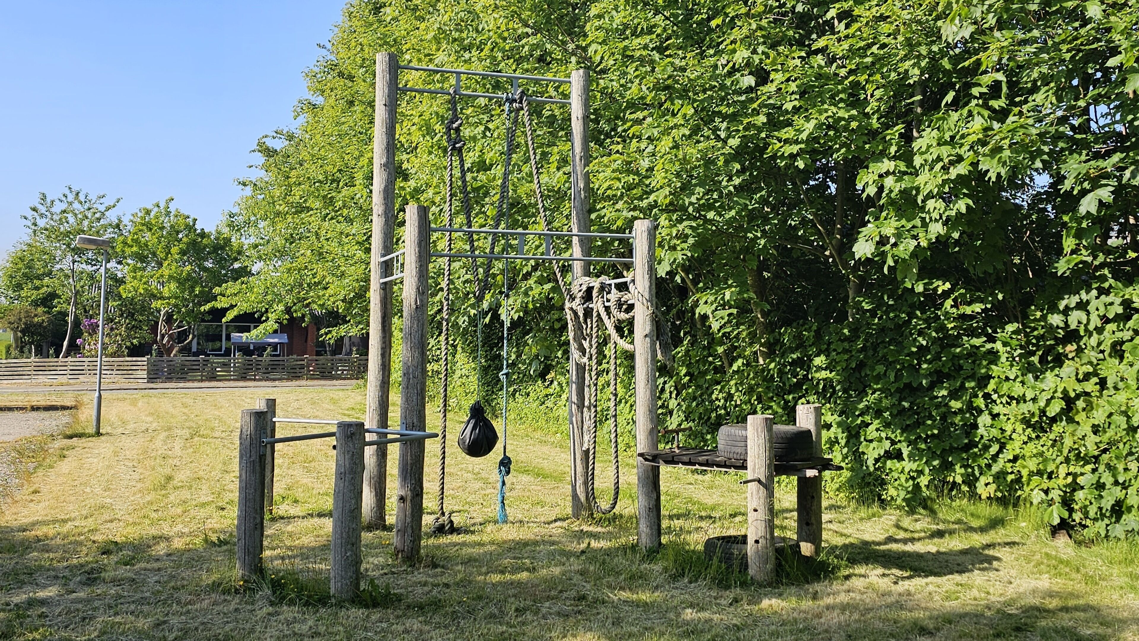 A playground with a climbing structure and a swing set.