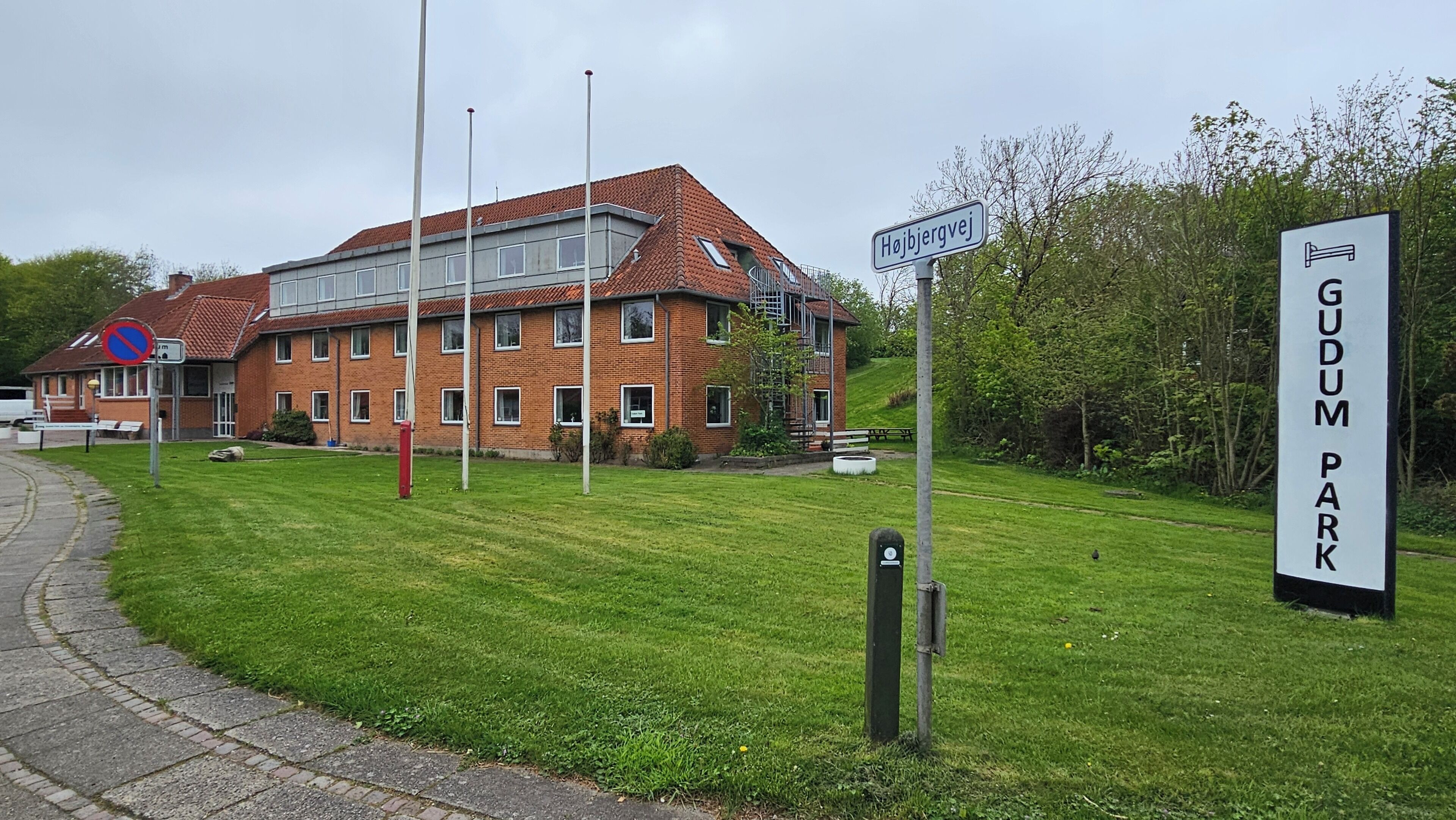 A building with a red-tiled roof and a sign indicating 'Højjordvej' and 'GUDUM PARK'.
