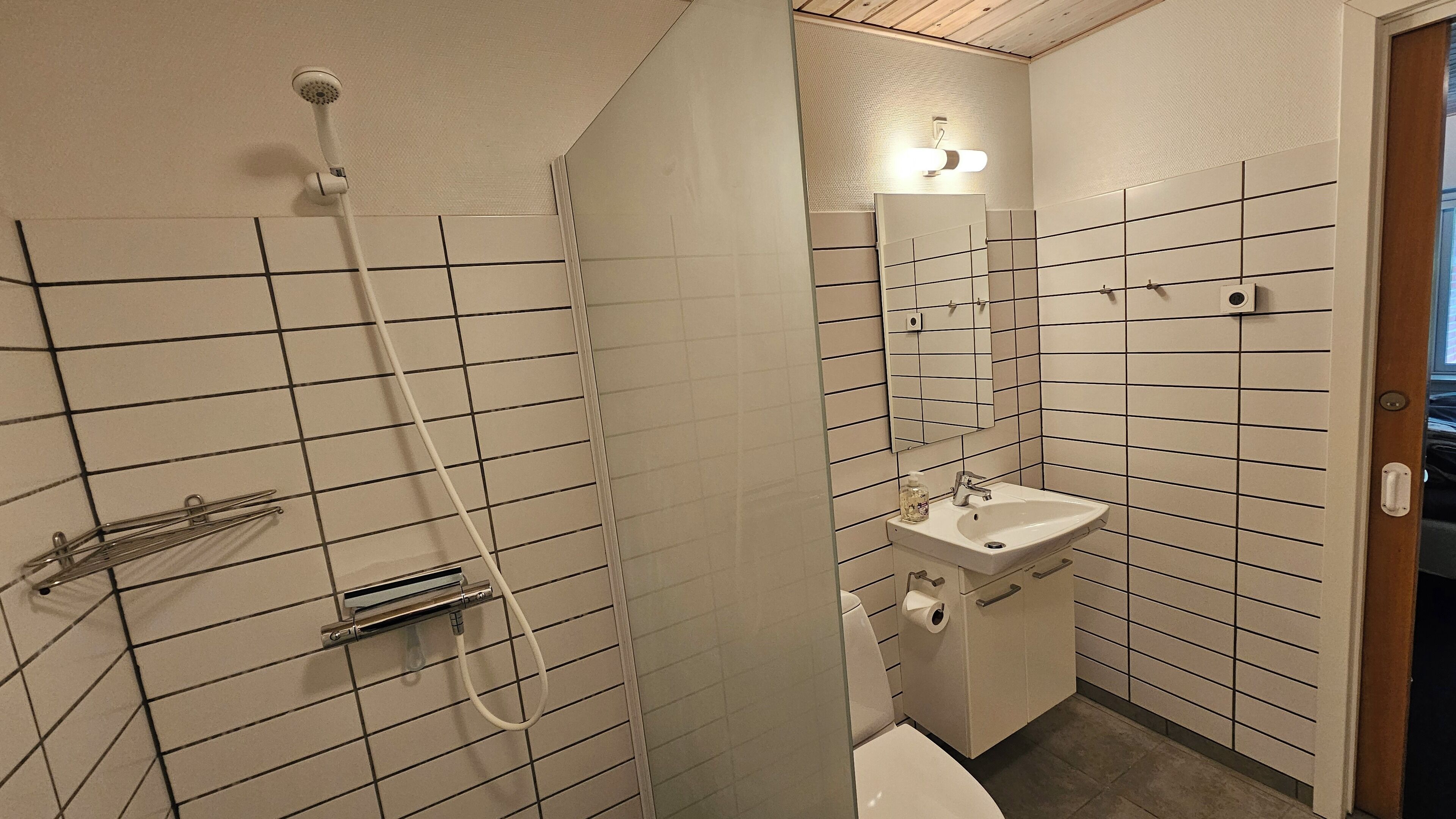 Un baño con ducha, lavamanos e inodoro.