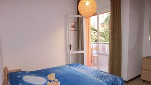 Une chambre à coucher avec un lit, une fenêtre, une porte et une vue sur l’extérieur.