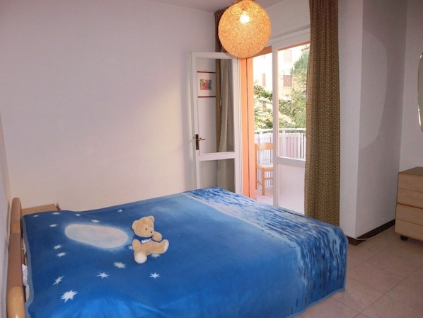 Une chambre à coucher avec un lit, une fenêtre, une porte et une vue sur l’extérieur.