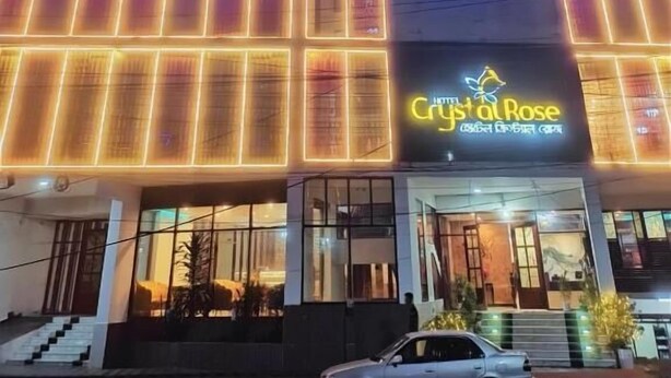 A building with illuminated blue and orange neon lights, featuring a sign for 'Crystal Rose'. - Hotel Crystal Rose sylhet (Sylhet)