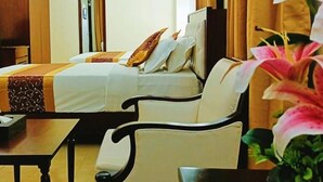 A hotel room with a bed, a sofa, a table, and a TV. - Hotel Crystal Rose sylhet (Sylhet)