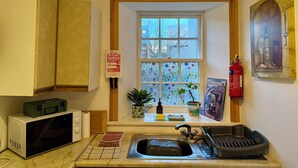 Une cuisine équipée d’un four à micro-ondes, d’un évier et d’une fenêtre donnant sur un beau paysage.