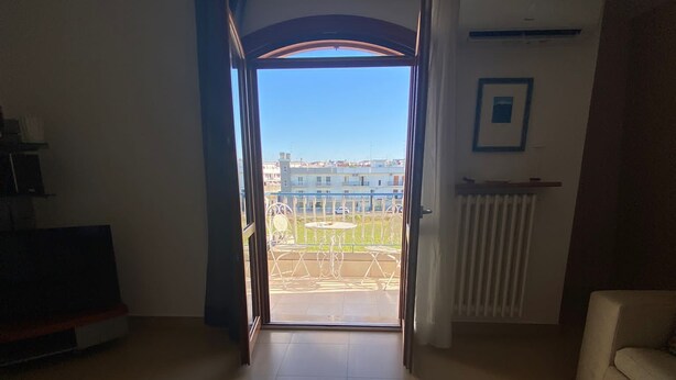 Una sala de estar abierta con vistas a un paisaje urbano a través de un amplio ventanal.