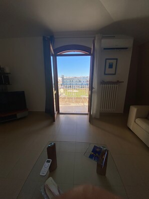 Un saló obert amb vista a un paisatge urbà a través d'una gran obertura.