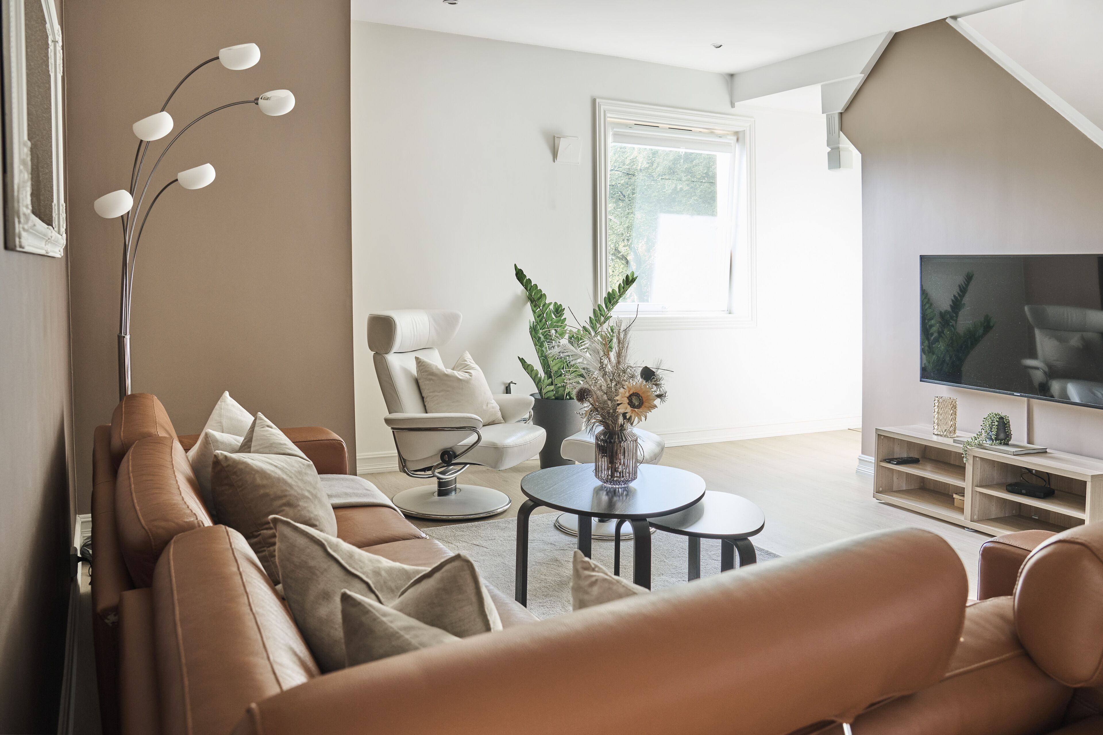 A modern living room with a sofa, coffee table, and a TV.