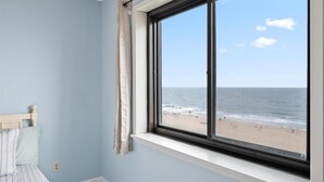 Una habitación con un amplio ventanal con vistas a la playa.