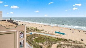 Vista a la playa desde un edificio con piscina y playa de arena.