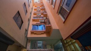 A narrow corridor between buildings with balconies and air conditioning units. - MeroStay 210 Hotel Tone (Kathmandu)